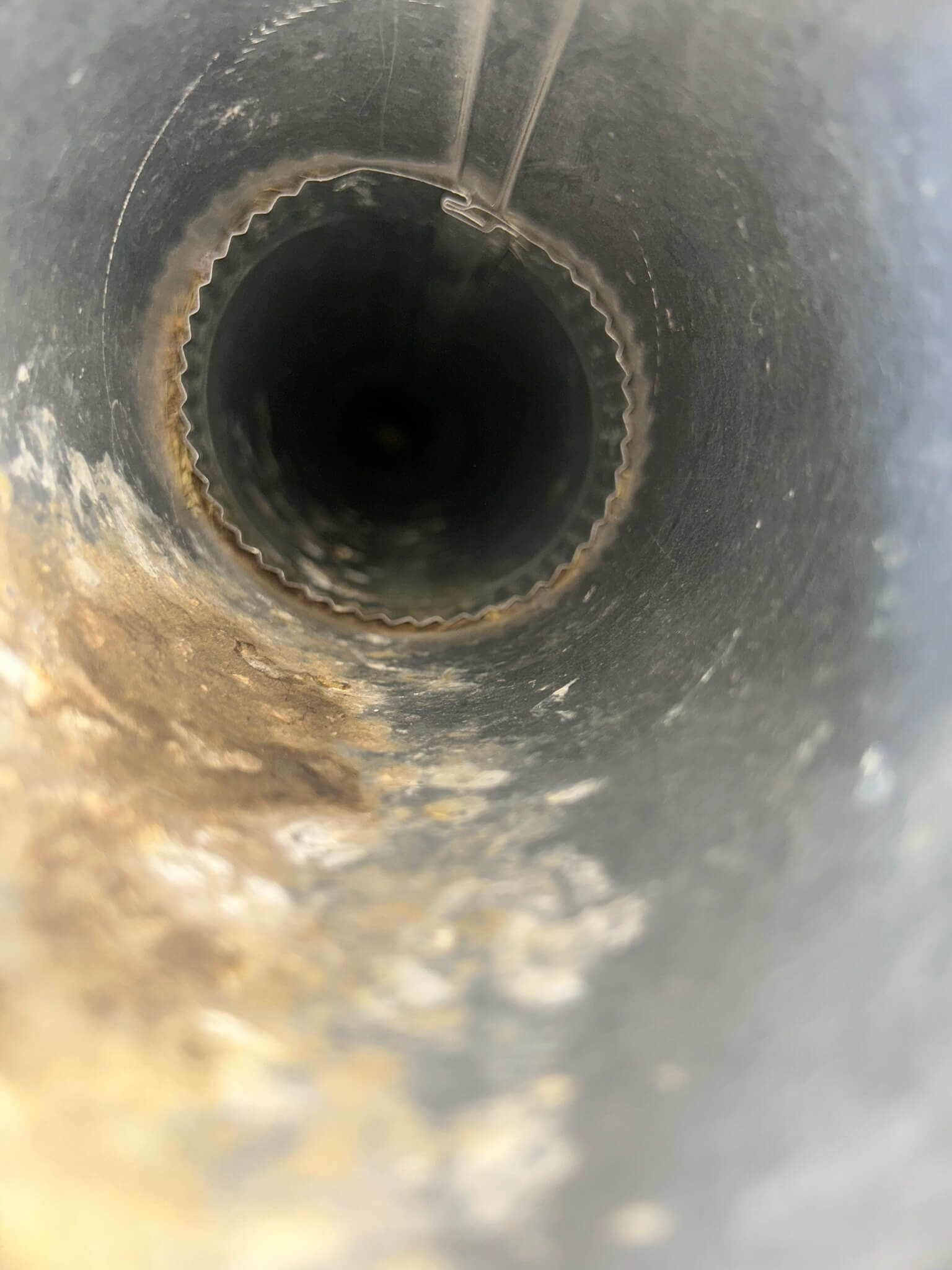 Dryer vent before cleaning, showing lint and debris buildup