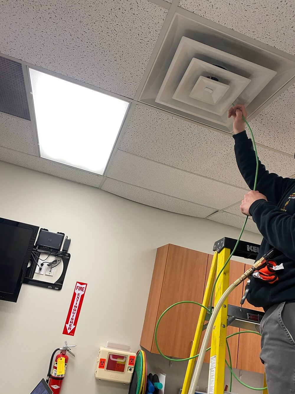 Technician performing duct cleaning in an attic